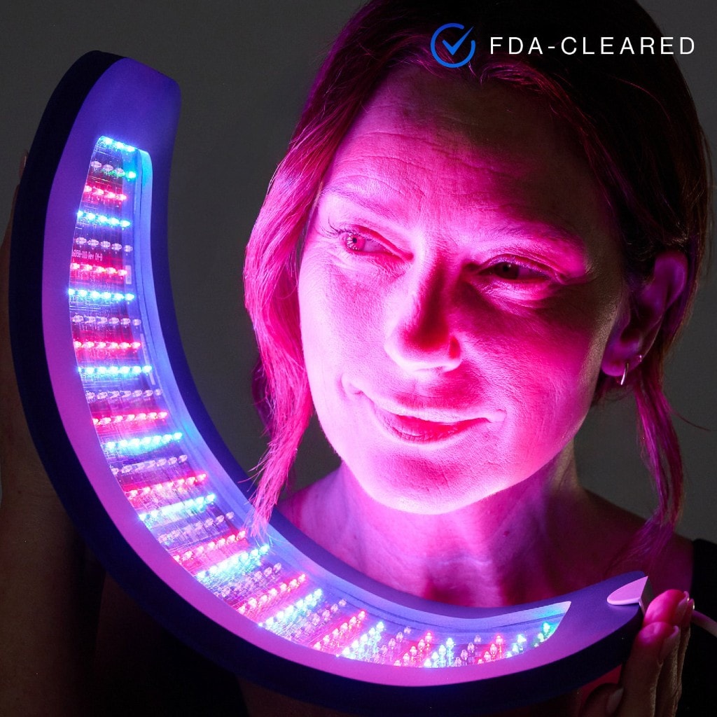 Celluma NOVA flexible LED panel held beside the face, emitting red, blue, and near-infrared light
